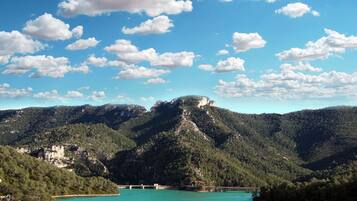 Paisaje montañoso con un lago turquesa y un puente.