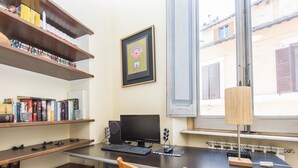 A home office with a desk, computer, and bookshelf. - RSH Piazza Navona Charming Apartment 2 (Rome)
