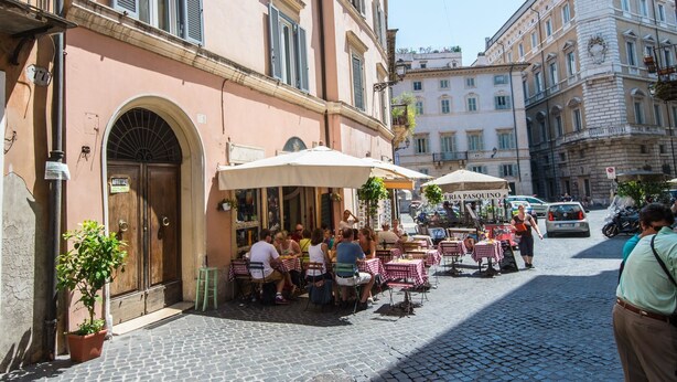 A cobblestone street with outdoor seating at a café, surrounded by historic buildings. - RSH Piazza Navona Charming Apartment 2 (Rome)