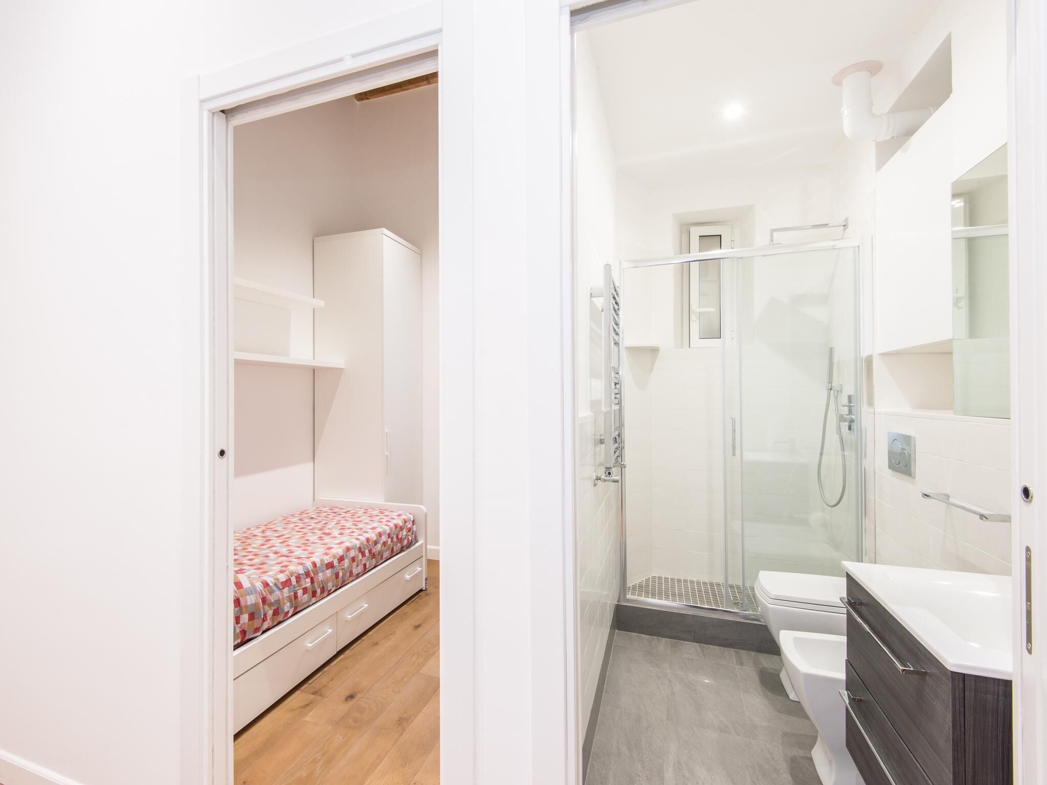 Une chambre à coucher comprenant un lit, une armoire et une salle de bain avec douche, toilettes et lavabo.