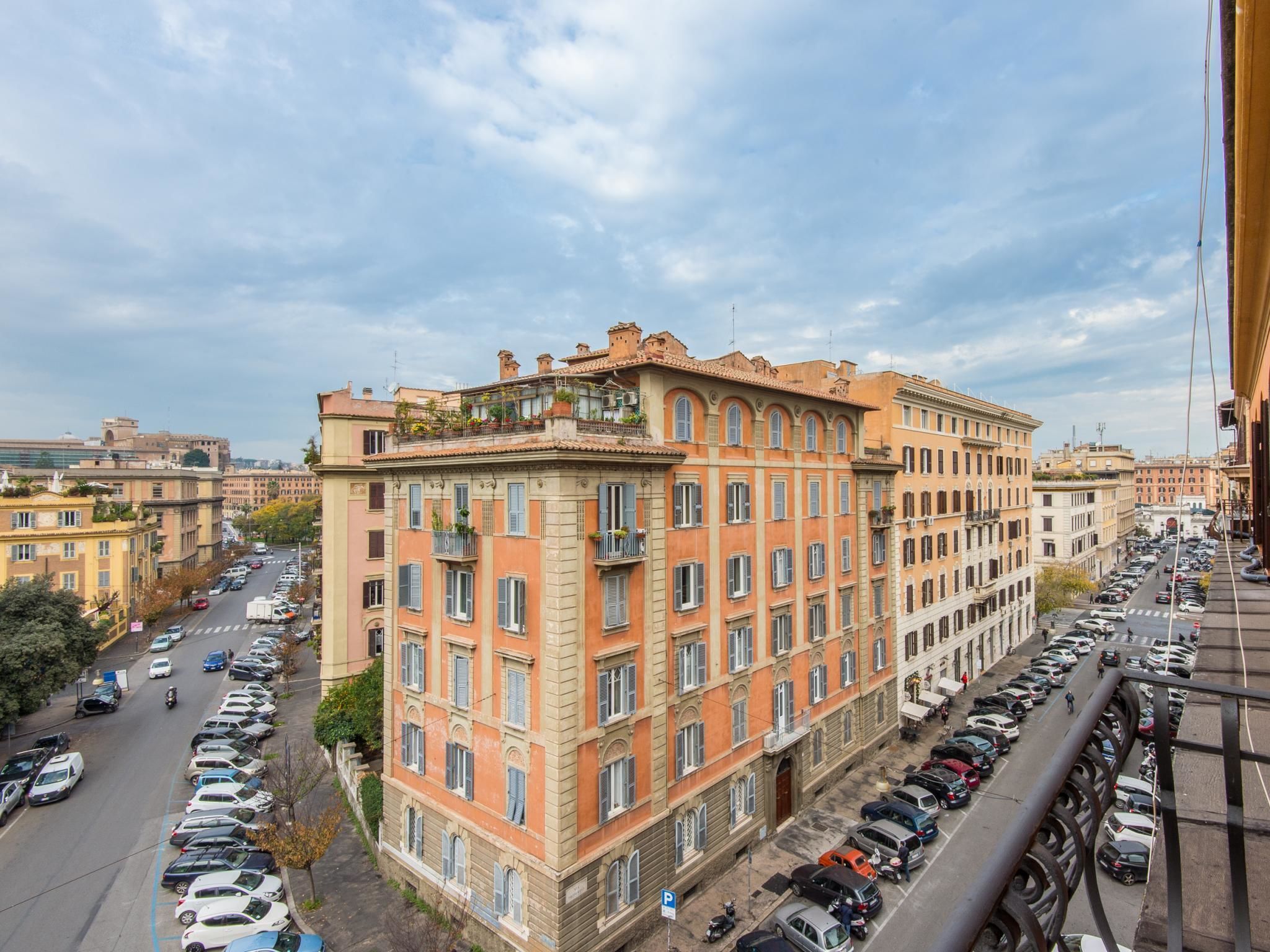 A multi-story building with a row of parked cars in front.