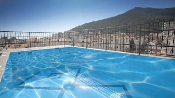 Una piscina al aire libre de temporada, sillones reclinables de piscina