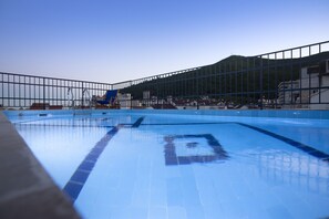 Una piscina al aire libre de temporada, sillones reclinables de piscina