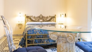Une chambre à coucher avec un lit, des tables de chevet et une table avec un plateau en verre.