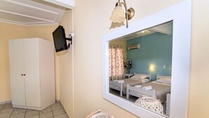 Un dormitorio con cama, mesita de noche, espejo y armario.