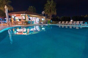 En säsongsöppen utomhuspool, parasoller och solstolar