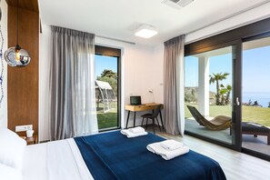 Ett hotellrum med en säng, ett skrivbord med en dator, en stol och utsikt över omgivningarna.