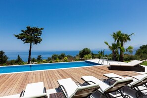 Piscine extérieure, parasols de plage, chaises longues