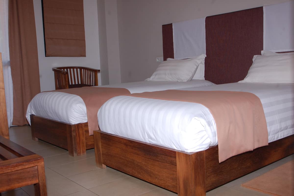 A double bed with a wooden frame and two pillows.