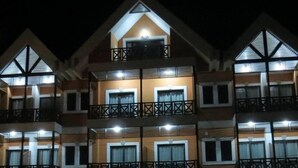 Un hotel de varios pisos con balcones y ventanas amplias.
