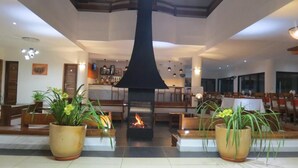 Un vestíbulo con chimenea central, zonas de estar y un bar.