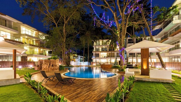 A modern hotel with a swimming pool, outdoor seating, and well-lit pathways. - The Eternal Wave by Krish Retreat (Calangute)