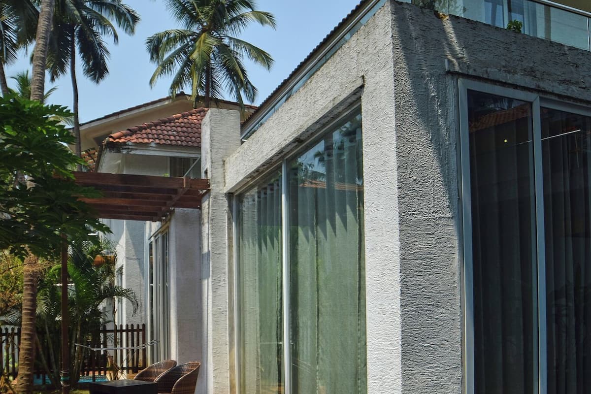 A modern house with a swimming pool, large glass windows, and a patio area.