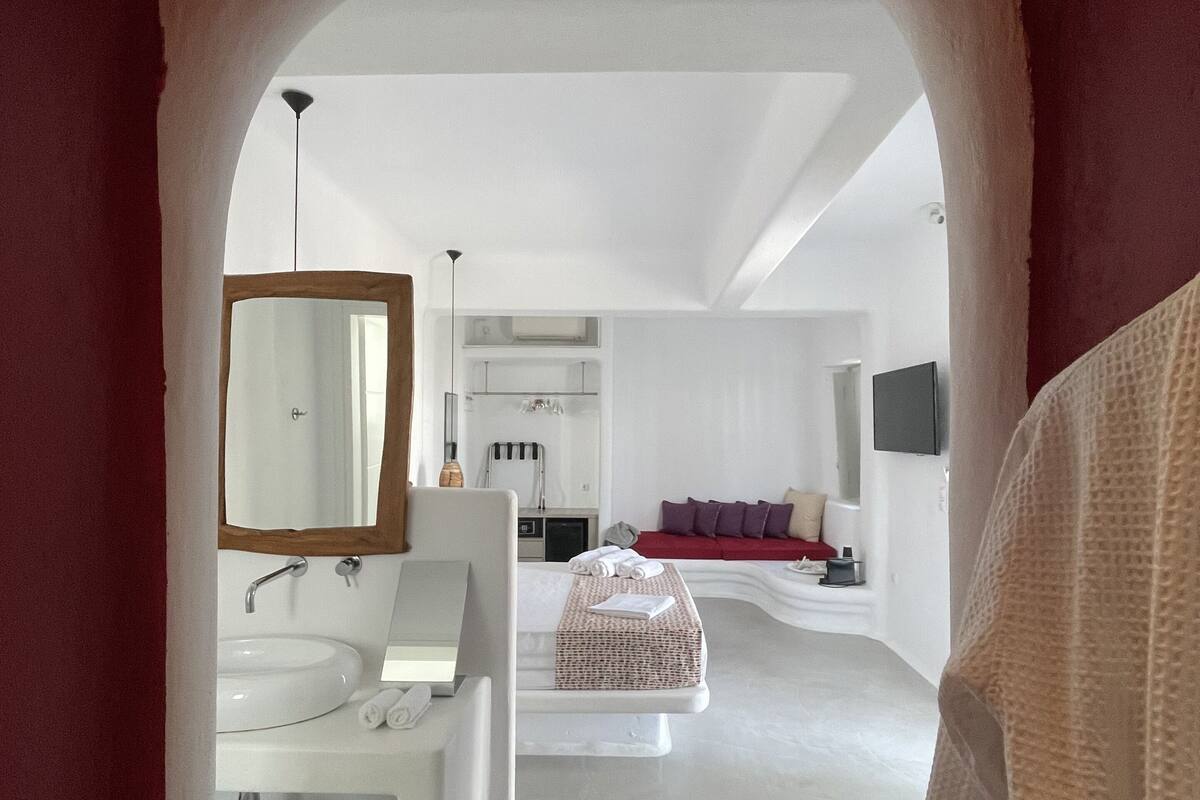 A modern bathroom with a white sink, mirror, and towel rack.
