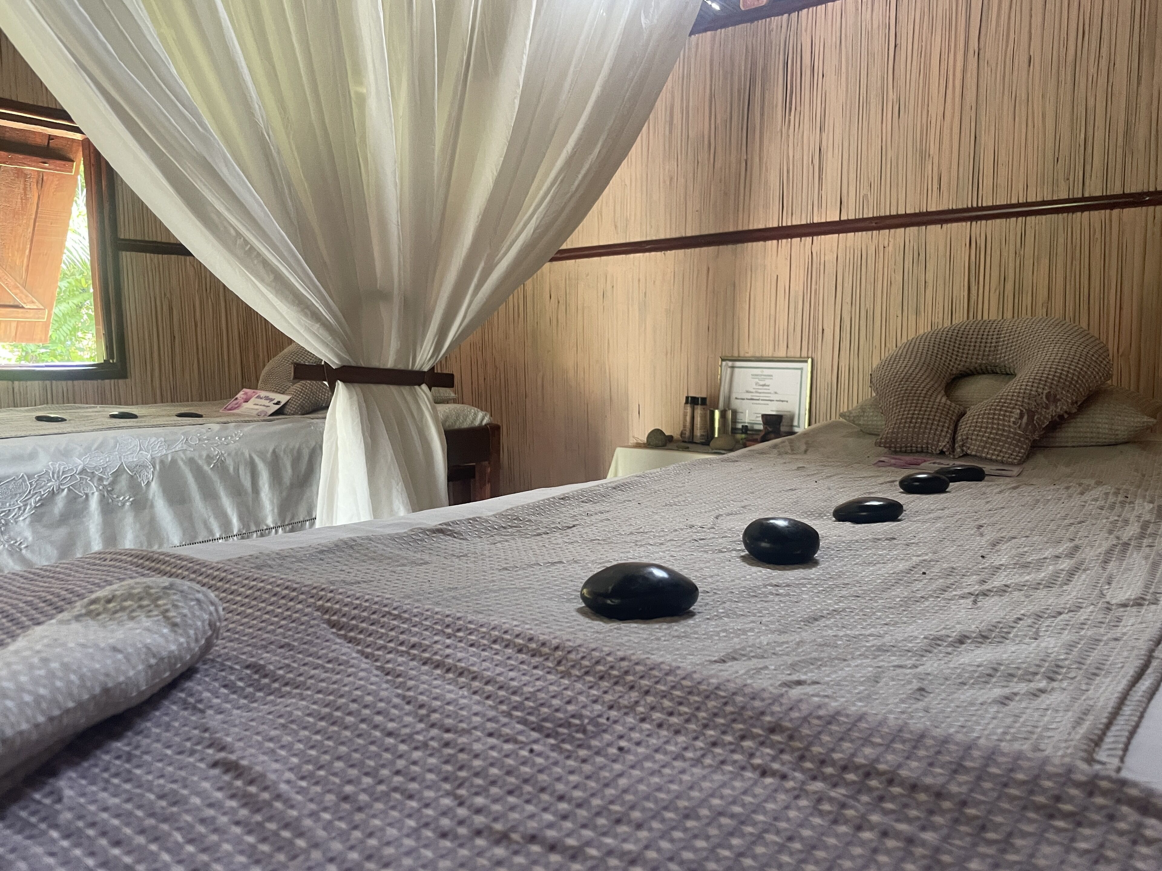 A room with a bed, a massage table, and a massage stone arrangement.