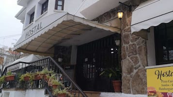 Hostel with a covered outdoor area and a staircase leading up to the entrance.