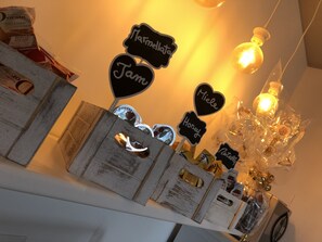Exposição de diversos alimentos, incluindo potes e caixas, com etiquetas como 'Marmellata', 'Jam', 'Mel' e 'Nutella'.