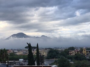 Montanha parcialmente escondida por nuvens, com edifícios ao primeiro plano.