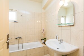 Une salle de bain moderne avec une baignoire, un lavabo et un miroir.