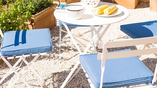 A terrace with a table, chairs, and potted plants. - Villa Alysso (Chania)