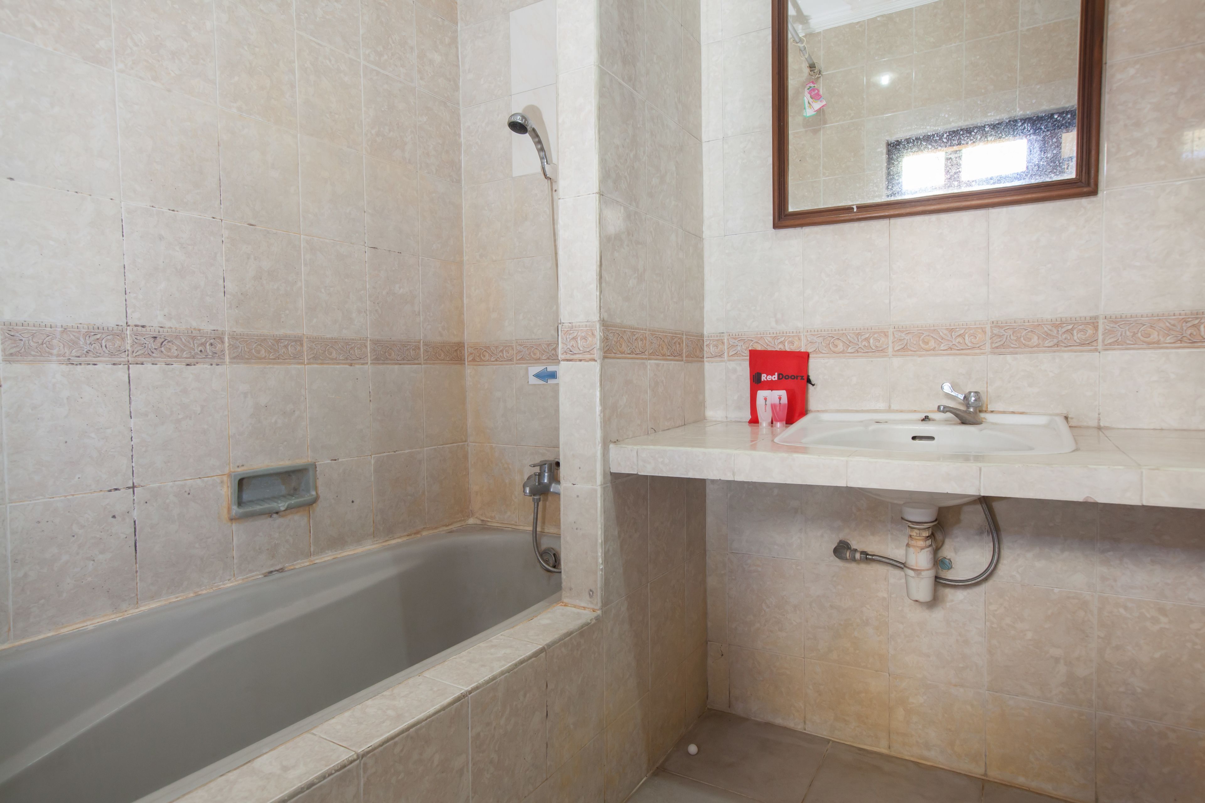 A bathroom with a bathtub, a sink, and a mirror.