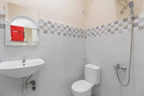 A bathroom with a sink, toilet, and shower. - RedDoorz near Grand Palladium (Medan)
