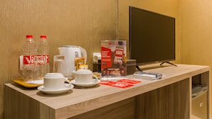 Una recepción con una estación de café, un televisor y un letrero de RedDoor.
