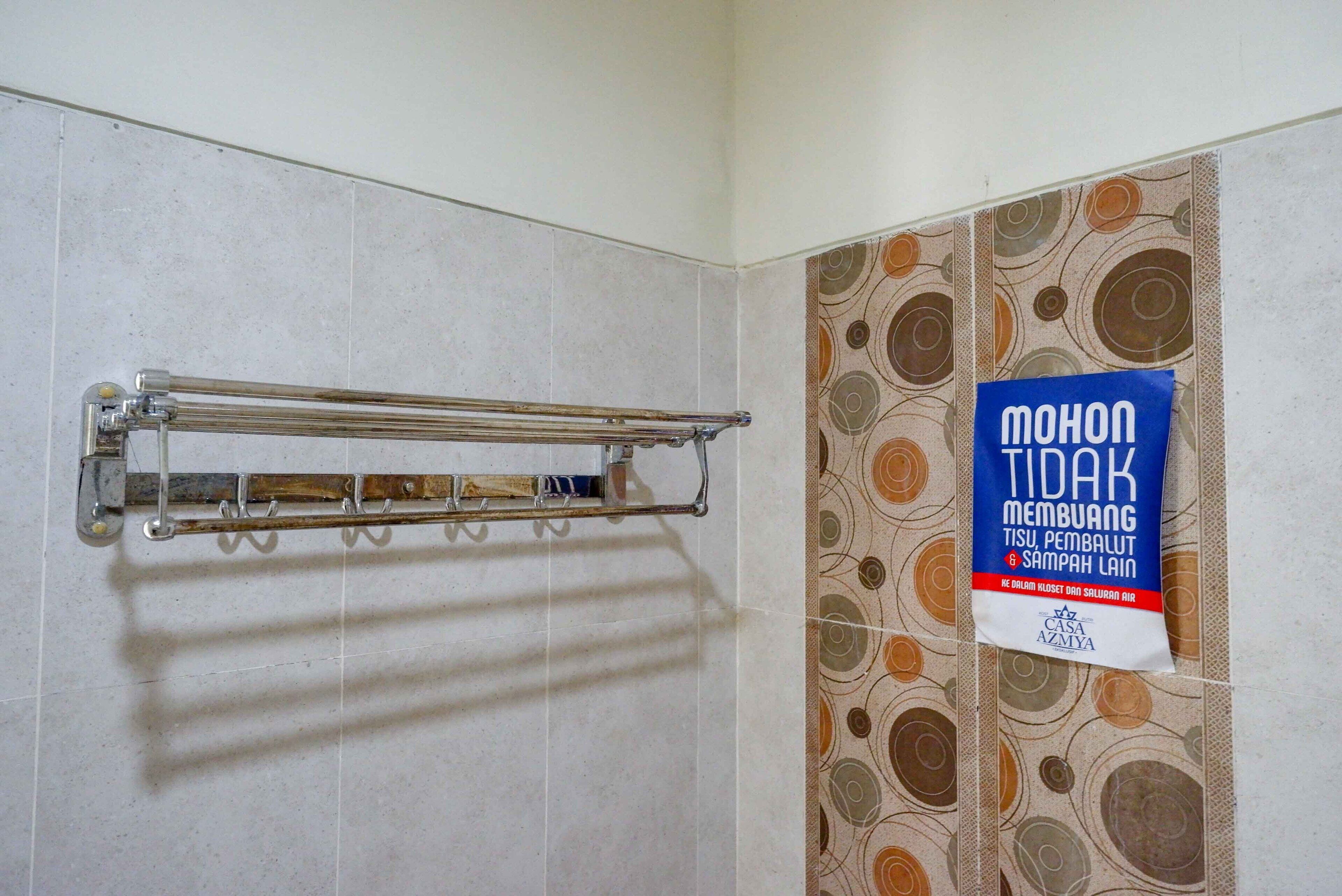 A bathroom with a towel rack and a sign on the wall.