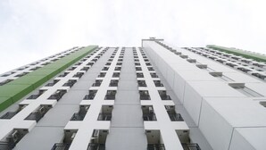 A high-rise building with a grid of balconies and a green section on the left. - RedLiving Apartemen Green Lake View Ciputat - Pelangi Rooms Tower E (South Tangerang)