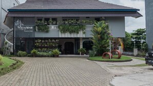 A two-story building with a tiled roof and a covered entrance. - RedDoorz Syariah Plus @ Banjarbaru (Banjarbaru)
