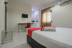 Une chambre d’hôtel équipée d  ’un lit, d’un bureau, d’une chaise, d’une télévision et d’un appareil de climatisation.