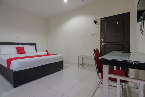 Une chambre d’hôtel avec un lit, un bureau et une chaise.