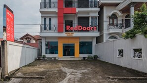 Ein modernes Gebäude mit einem auffälligen Schild in Rot und Gelb, auf dem "RedDoorz" steht.