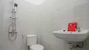 A bathroom with a toilet, a sink, and a shower. - RedDoorz near Sultan Thaha Airport Jambi (Jambi)