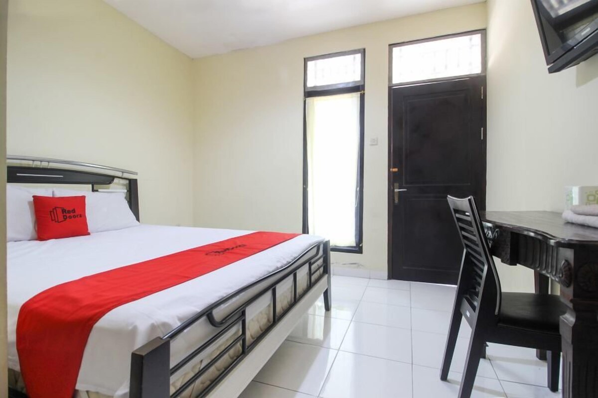 Ein Hotelzimmer mit Bett, Schreibtisch und Stuhl.