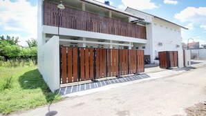 A two-story residential building with a balcony, a garage, and a gated entrance. - RedDoorz Syariah @ Griya Izzara Guest House (Yogyakarta)