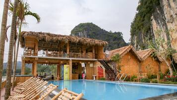 Una piscina al aire libre, sillones reclinables de piscina