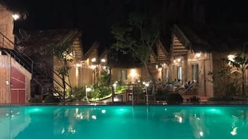 Una piscina al aire libre, sillones reclinables de piscina