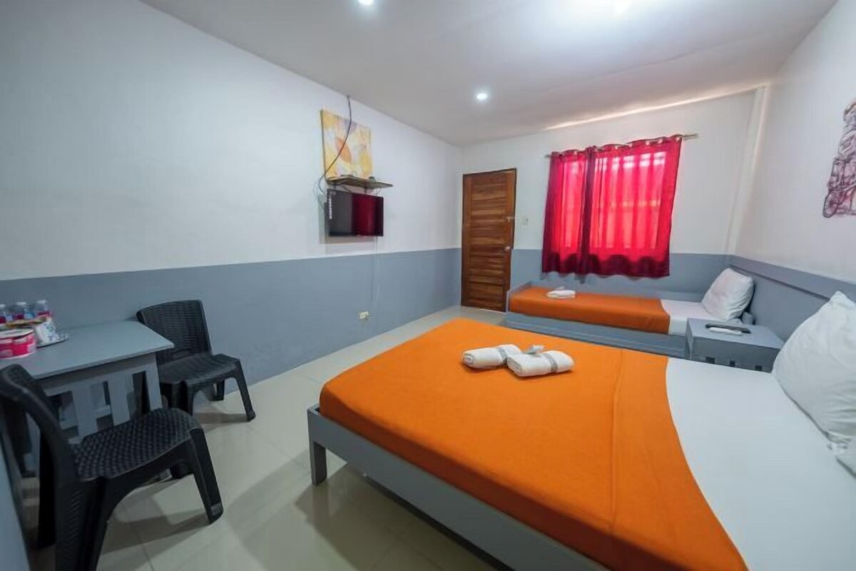 Une chambre d’hôtel équipée d’un lit, d’un bureau, d’une chaise, d’un canapé et d’une télévision.