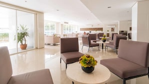 A spacious, modern living area with comfortable seating, a central coffee table, and a large window providing natural light. - RedDoorz Premium @ SMDC Fairview (Quezon City)
