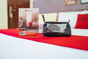 A RedDoorz promotional sign and a black mesh bag on a bed with a red blanket. - RedDoorz @ Tagaytay Road (Tagaytay)