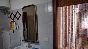 Departamento, varias camas, para no fumadores, vista a la ciudad | Lavabo en el baño