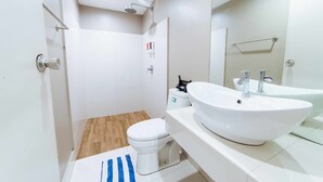 Un baño moderno con inodoro, bidé y lavamanos dobles.