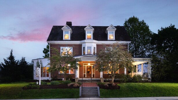 A brick house with a front porch, a small attached garage, and a well-maintained lawn. - Keystone Inn Bed and Breakfast (Gettysburg)
