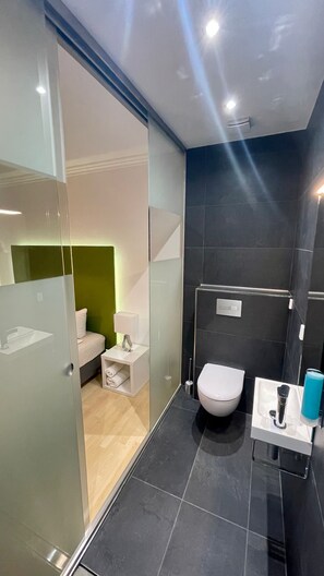 A modern bathroom with a glass partition, a toilet, a sink, and a shower area. - smart&beautiful Deluxe (Nordkirchen)