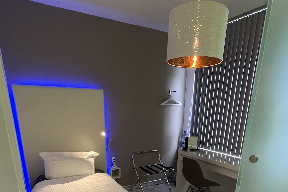 Un dormitorio con una cama, un escritorio y una silla.