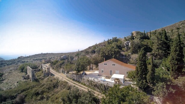 A building with a red roof, surrounded by trees and hills. - Rodies Cottage (Kefalonia)