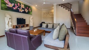 A living room with a sofa, coffee table, and artwork on the wall.