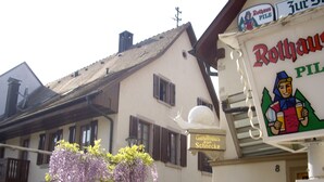 A building with a sign reading "Rothaus Pils" and another sign "Gästehaus zur Schnecke".