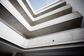 A multi-level concrete staircase with a skylight at the top. - ipartment Cologne Mülheim (Cologne)